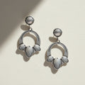 Pair of silver earrings with circular designs on a white background