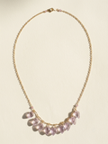 Gold-tone necklace with lilac petal charms on a fine chain