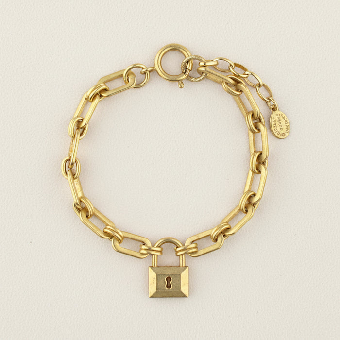 Gold-tone chain bracelet with padlock charm and round toggle clasp