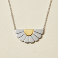 Necklace with a gold and silver pendant on a white background