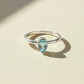 Silver gemstone ring with marquise-cut light blue stone, slim band.