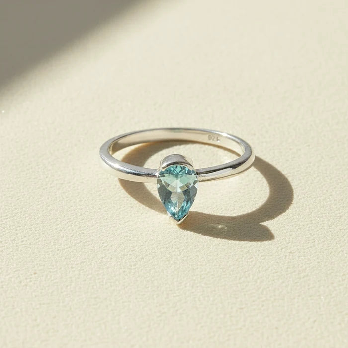 Silver gemstone ring with marquise-cut light blue stone, slim band.