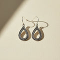 Silver-tone teardrop earrings with dark beaded trim and hook backs
