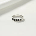 Silver ring with black moon phases on a white background