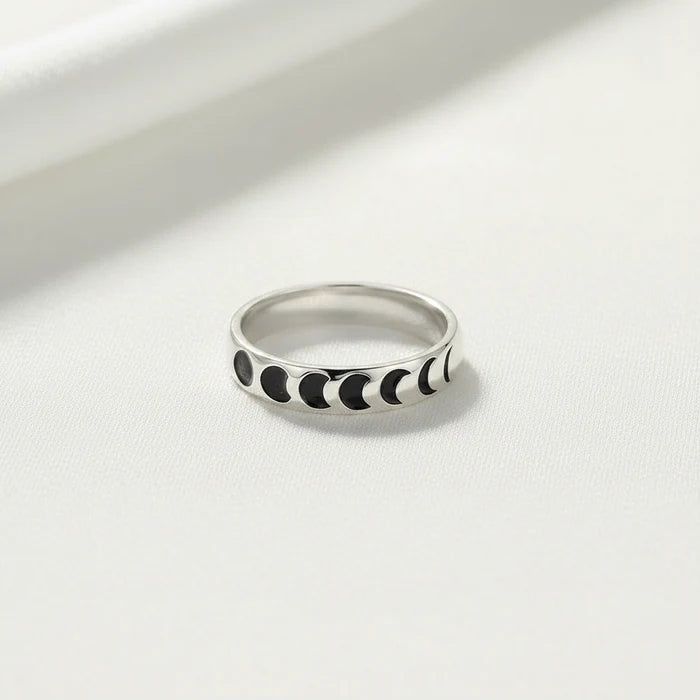 Silver ring with black moon phases on a white background