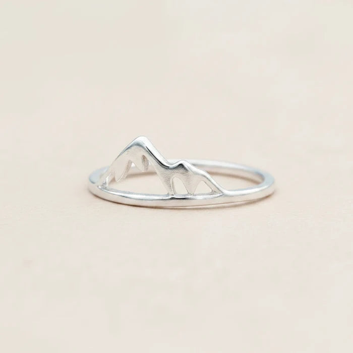 Silver ring with mountain design on a white background