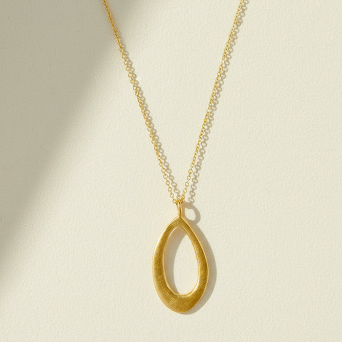 Gold leaf-shaped pendant necklace with slim chain and open teardrop charm