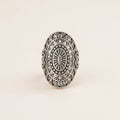 Silver ring with intricate geometric design on a white background