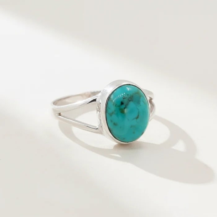 Silver ring with a turquoise stone on a white background