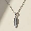 Oxidized feather pendant necklace with silver-tone chain, hanging feather charm center