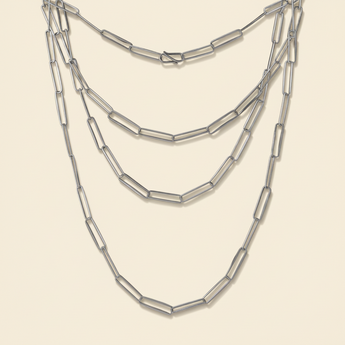 Triple-strand paperclip-link chain necklace with silver-tone linked segments.