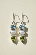 Silver-tone dangle earrings with blue gem, pearl drop, and green teardrop accents