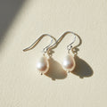 Pearl drop earrings on a white background