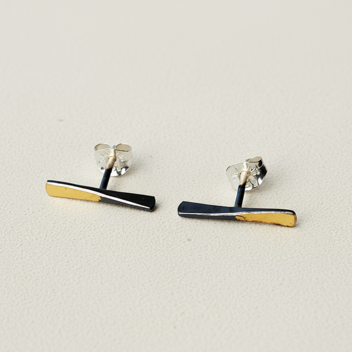 Bar stud earrings with black enamel and gold edge stripes, silver-tone backs