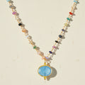 Chalcedony bezel charm necklace with oval blue pendant on multicolor beaded chain