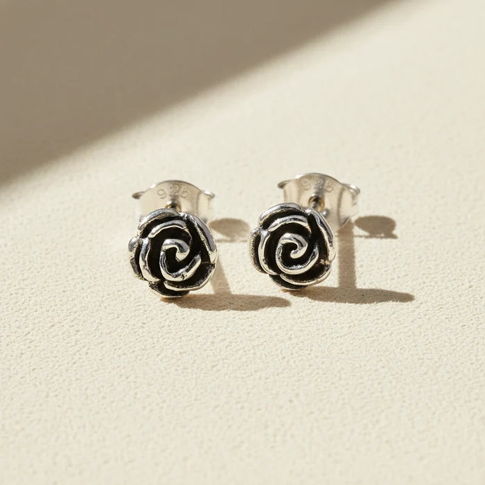 Silver-tone rose swirl stud earrings with black enamel center