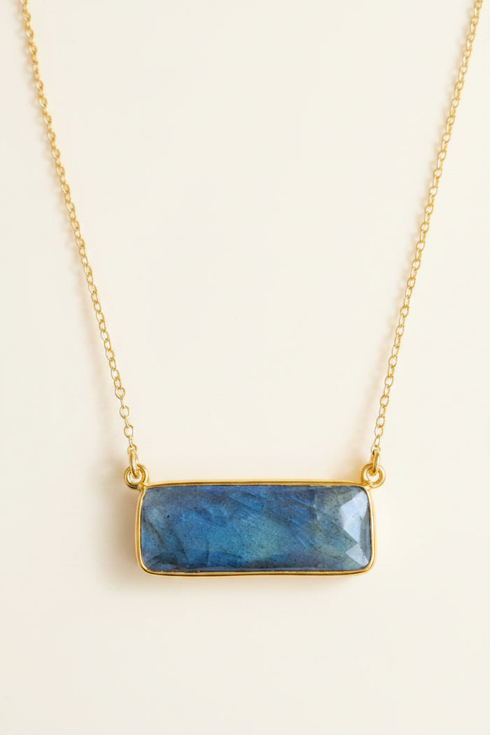 Necklace with a blue stone pendant on a white background