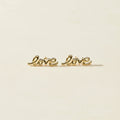 Gold Love script stud earrings, pair laid flat