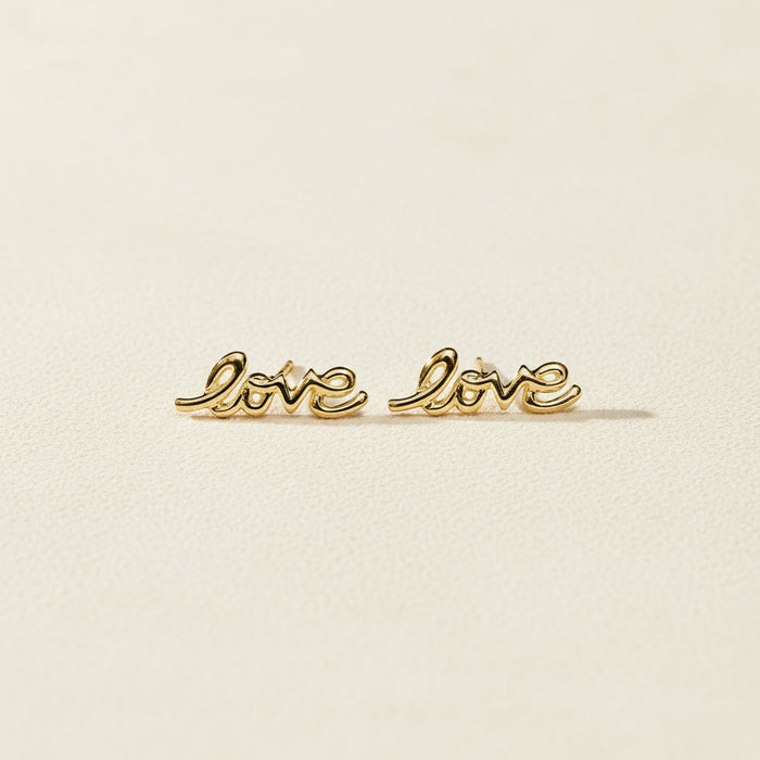 Gold Love script stud earrings, pair laid flat