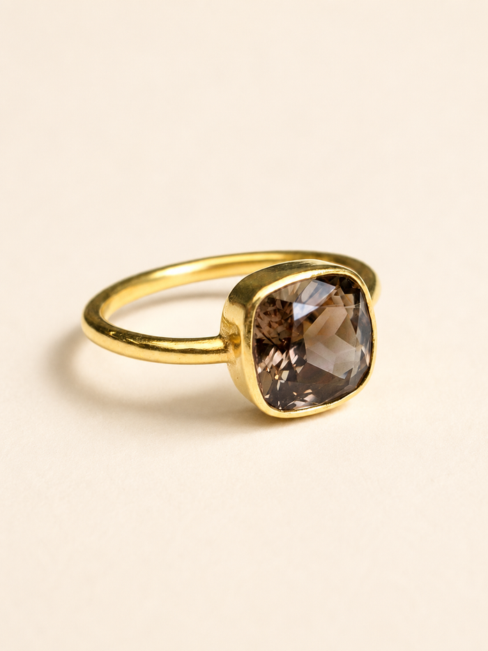 Gold-tone ring with faceted smoky quartz cushion stone bezel setting