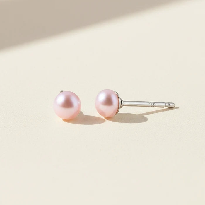 Pair of pink pearl earrings on a white background