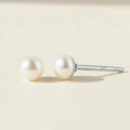 Pair of pearl stud earrings on a white background