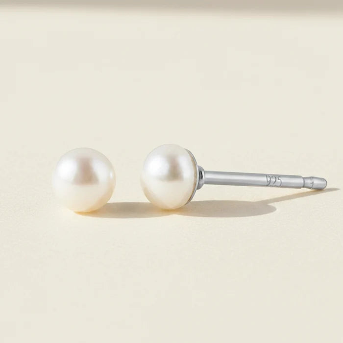 Pair of pearl stud earrings on a white background