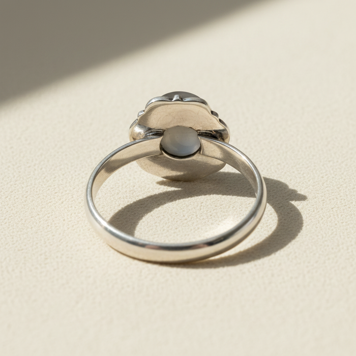 Silver-toned pearl ring with round white pearl and dark central setting