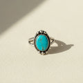 Turquoise oval cabochon ring with silver-tone bezel and bead accents