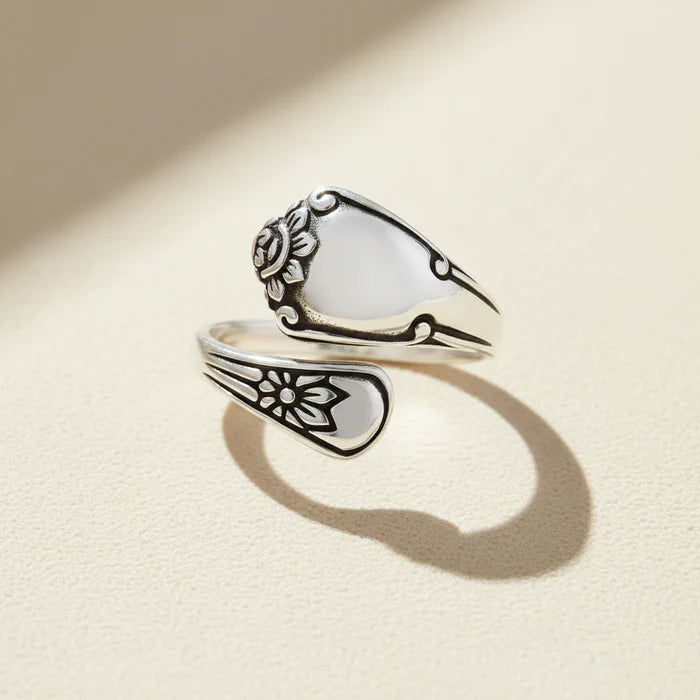 Silver spoon-shaped ring with engraved floral swirls and curved band