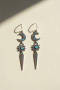 Stardust earrings with dangling crescent moons, blue starburst gems, and long teardrop charms