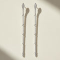 Silver-tone CZ dangle earrings with long drop design and small hanging stone accents