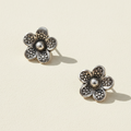 Sterling silver daisy stud earrings with textured petals and round center