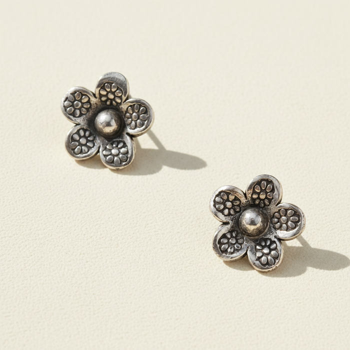 Sterling silver daisy stud earrings with textured petals and round center