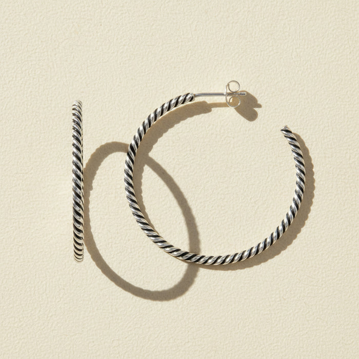 Black and white striped hoop earrings on a white background