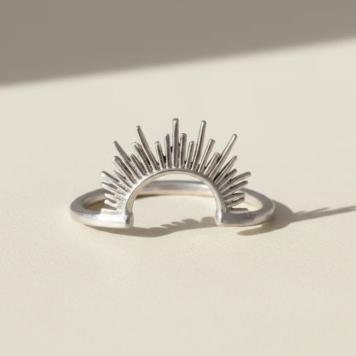 Sunrise ring, silver-tone open band with radiant sunburst rays.