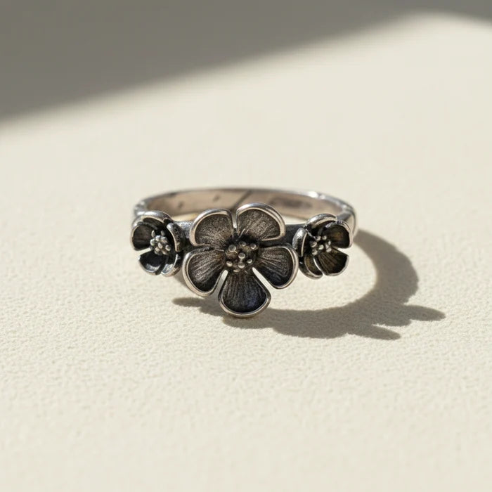 Silver flower ring with three bloom medallions on the band