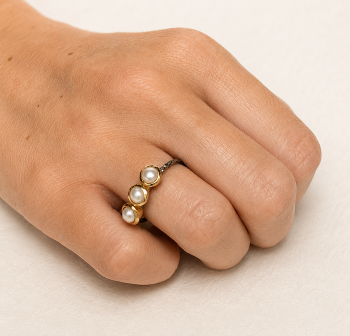 Gold-tone pearl ring with three white round pearls and dark textured band