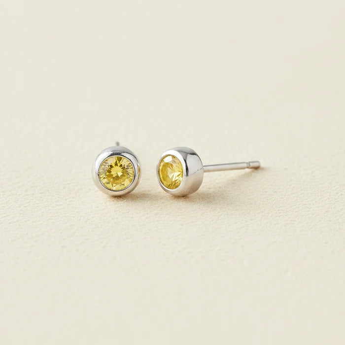 Tiny birthstone stud earrings with round yellow CZ in silver-tone settings