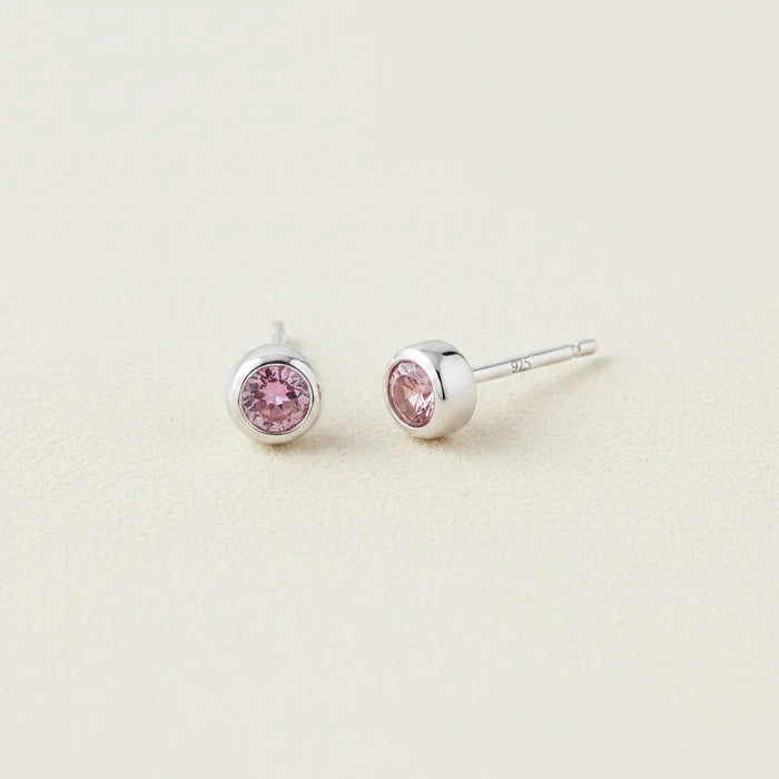 Tiny birthstone stud earrings with round pink CZ in silver-tone settings