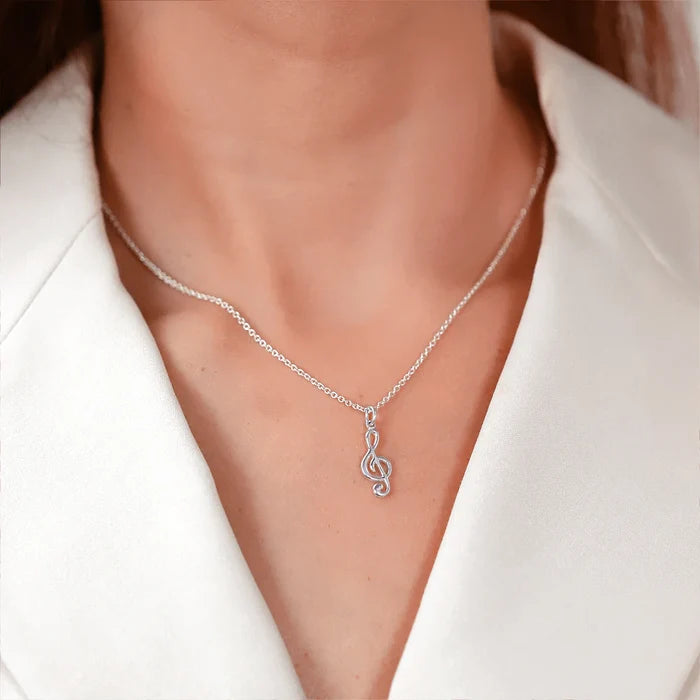 Treble clef pendant necklace on fine silver chain, close to neckline