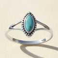 Silver oval turquoise gemstone ring with bezel and beaded border, marked 925