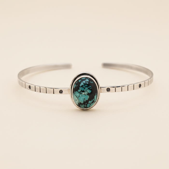 Silver bracelet with a turquoise stone on a white background