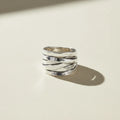 Silver ring with textured design on a white background