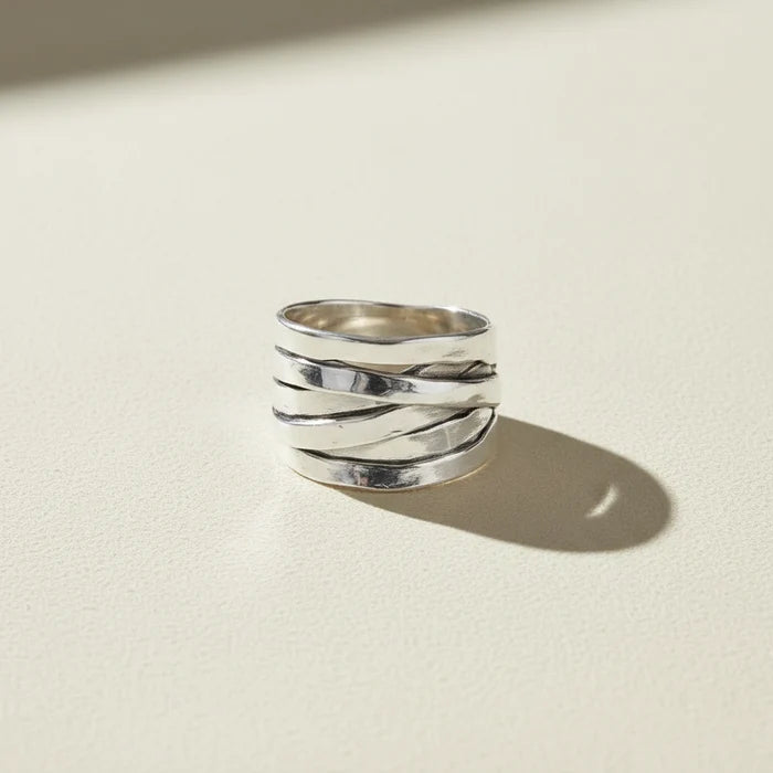Silver ring with textured design on a white background
