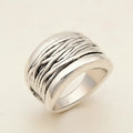 Silver ring with textured design on a white background